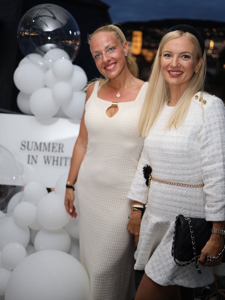 Zwei Gäste in Weiss vor weissen Ballons an der Summer in White