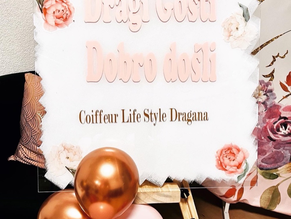 Weisse Tafel mit der Aufschrift Dobro došli und Blumen
