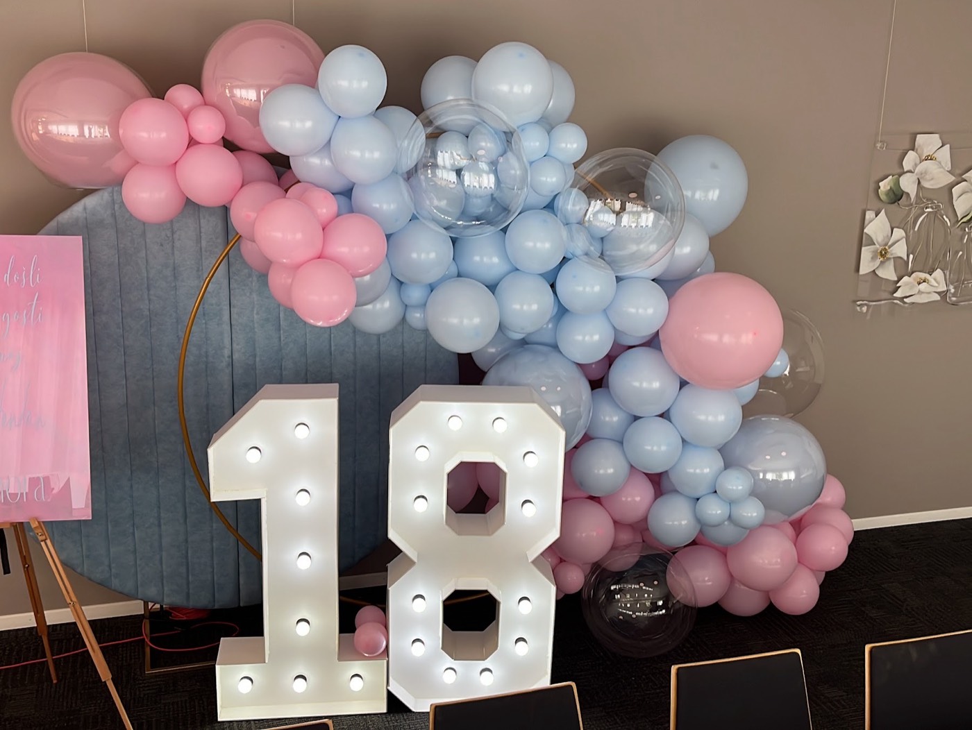 Leuchtzahl 18 vor Ballons in Rosa und Hellblau