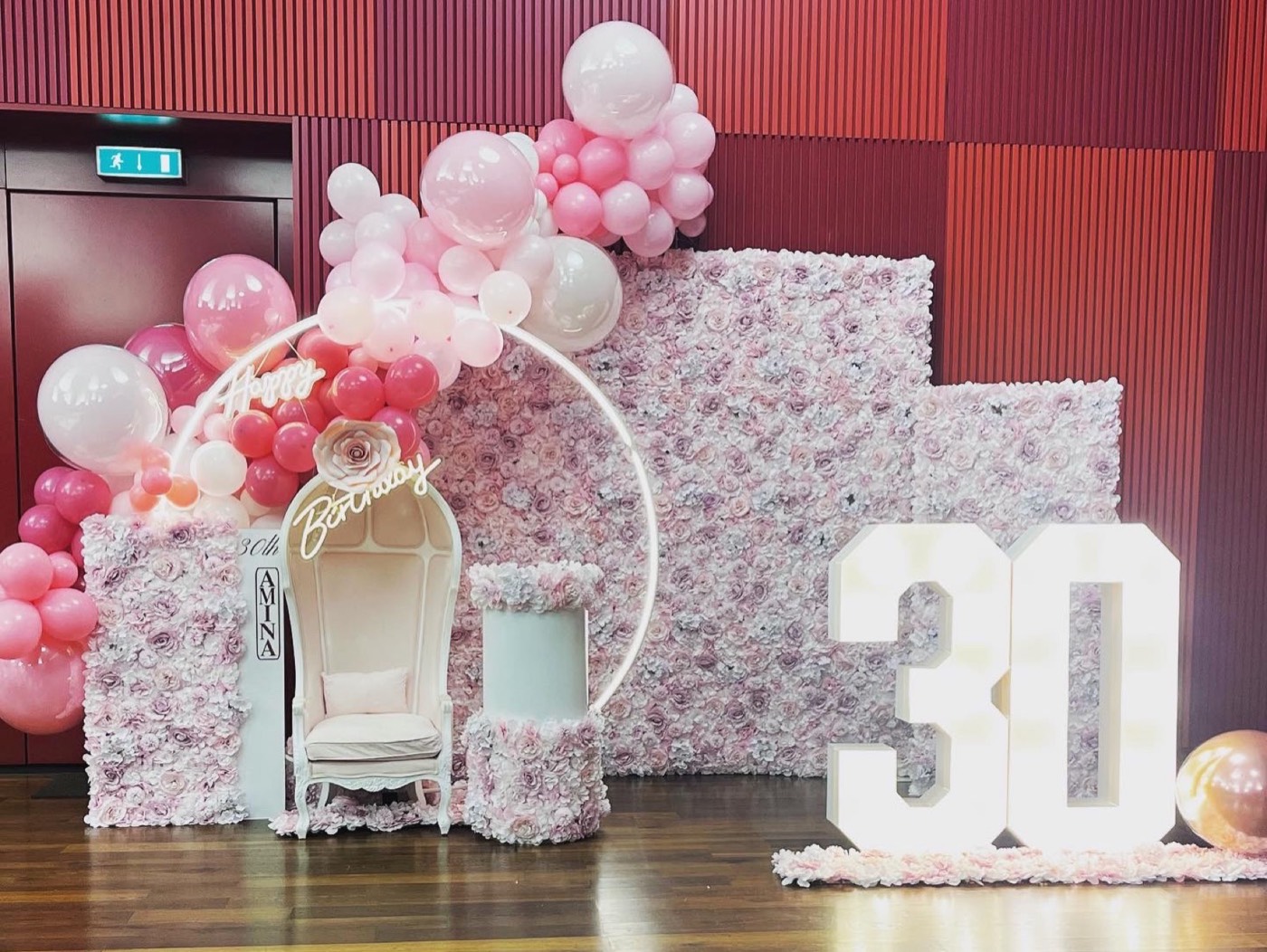 Leuchtzahl 30 neben einer rosa Blumenwand mit weissem Thron