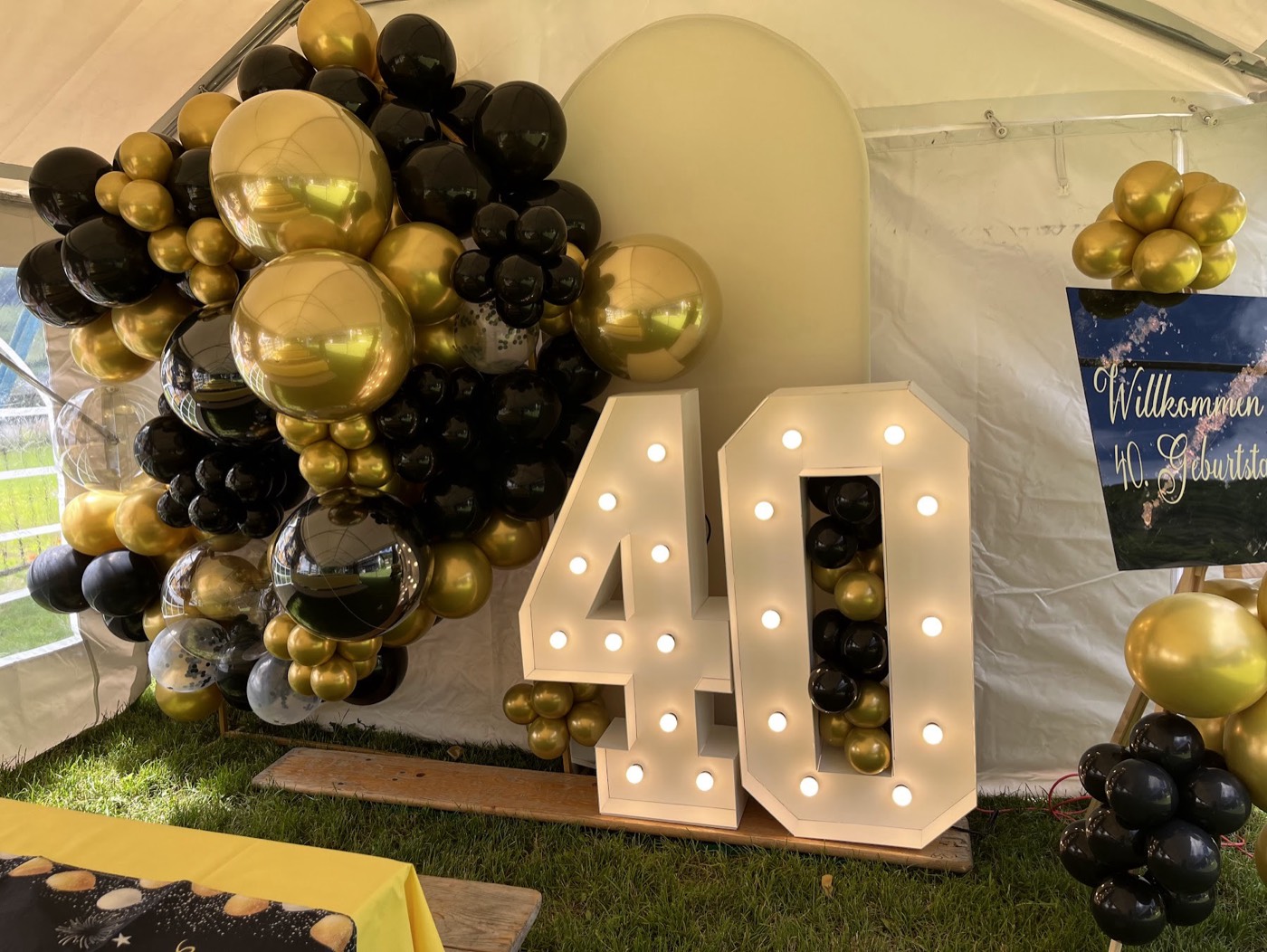 Leuchtzahl 40 vor Ballons in Schwarz und Gold